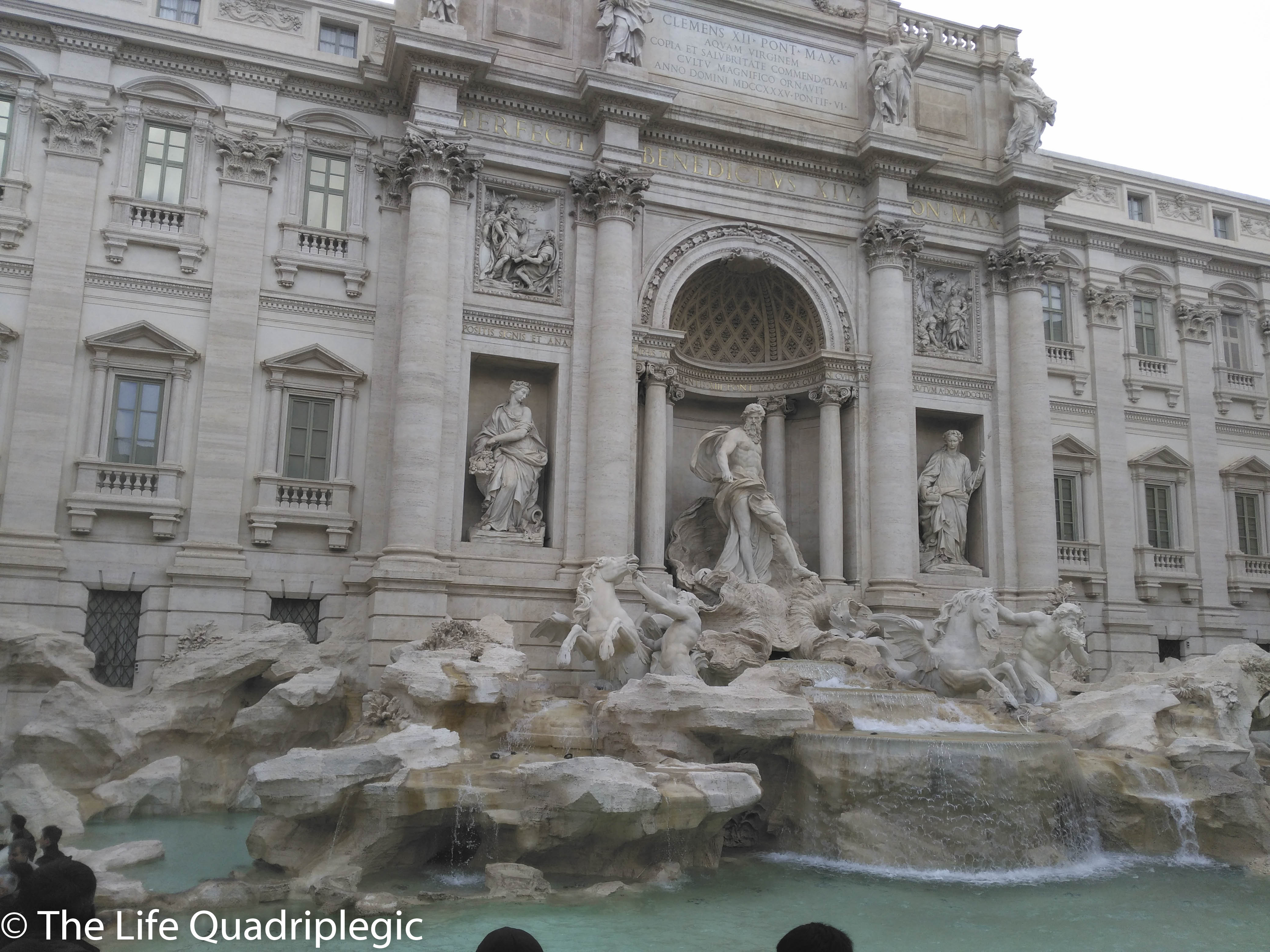 The Trevi Fountain in Rome, featuring a grand baroque design and intricate sculptures, surrounded by visitors in a bustling square.