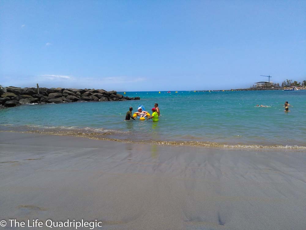 A man sat in a floating beach chair in the shallow Sea close to the beach