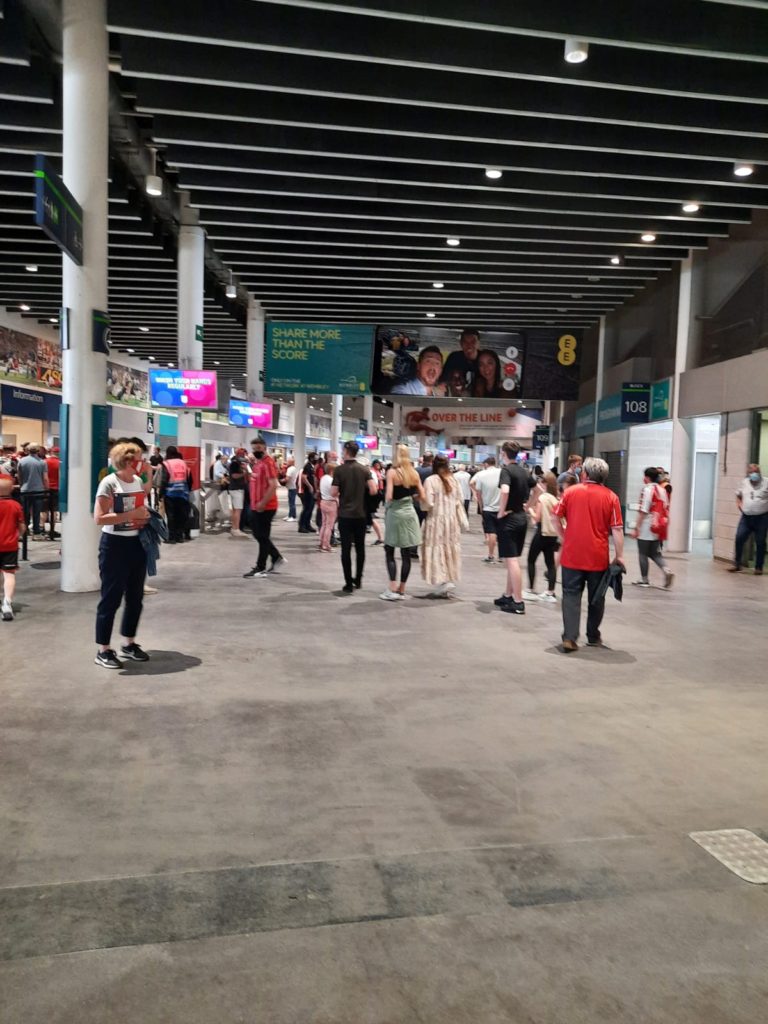 People walking on the concourse inside of the stadium