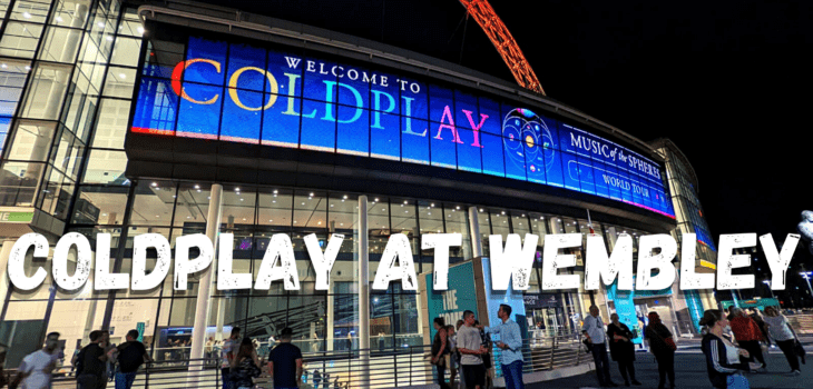 Wembley Stadium at night with a large digital sign reading Welcome to Coldplay and crowds outside; bold text across the image says COLDPLAY AT WEMBLEY.