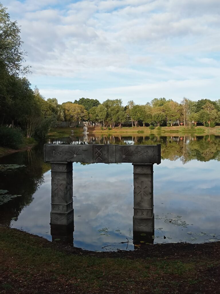 A lake with trees around the edge of it and still reflective water