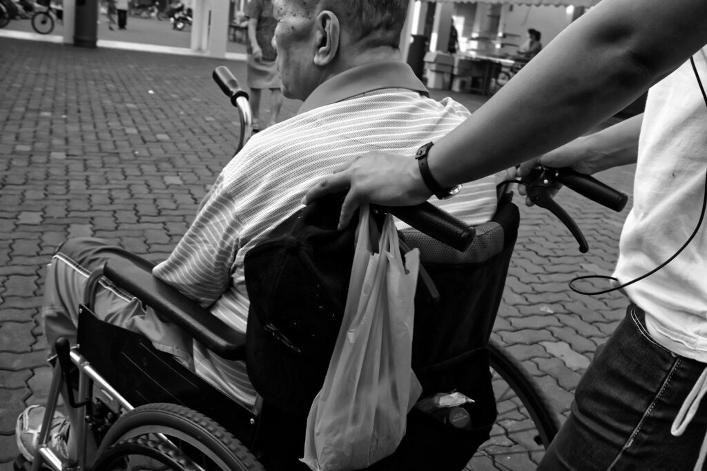 a man in a wheelchair being pushed along