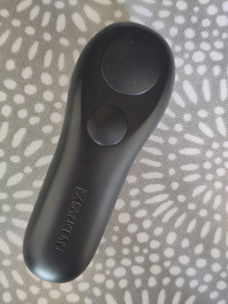 A plastic remote control with one large button at the end and a smaller button underneath it underneath it