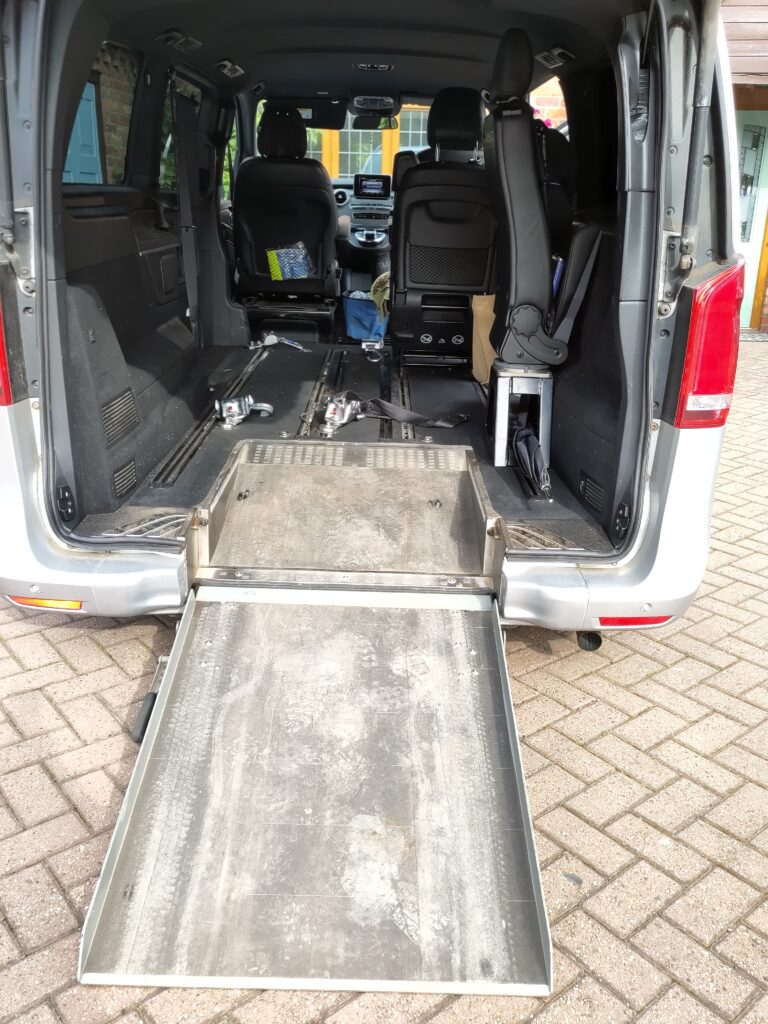 Interior view of a Mercedes V250 wheelchair accessible vehicle with an extended ramp, showcasing the spacious area for a power chair.