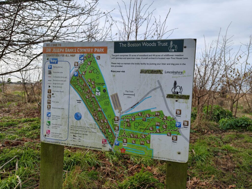 Information sign at Sir Joseph Banks Country Park displaying a map and amenities, surrounded by greenery.
