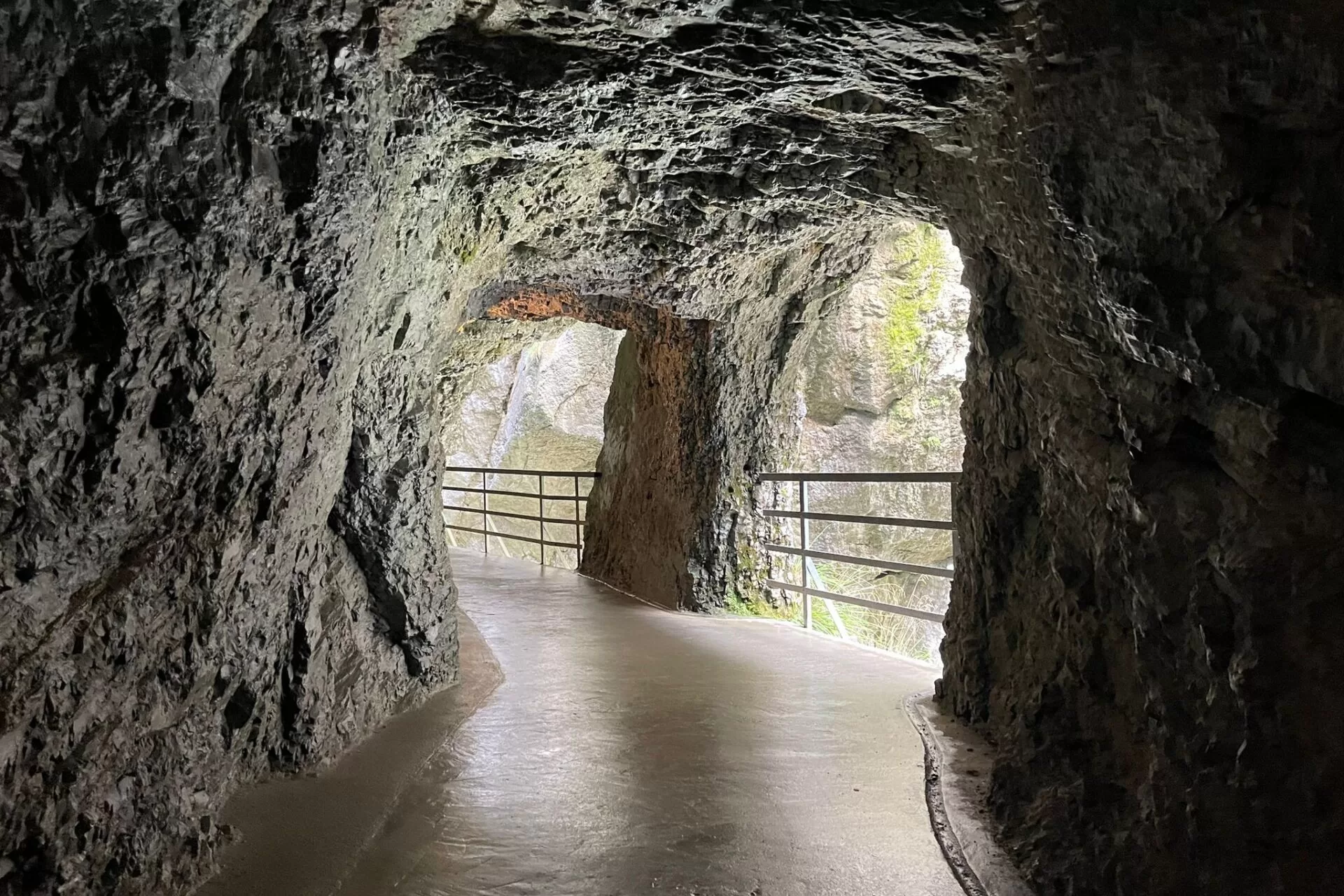 A pathway through Aare Gorge, showcasing rocky walls and a railing along the edge.