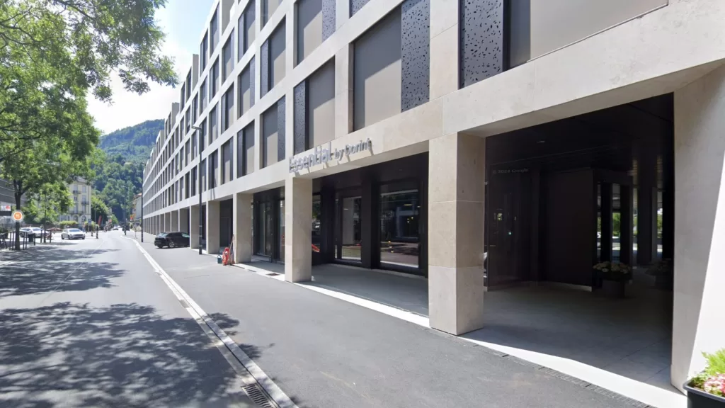 View of the Essential by Dorint hotel in Interlaken, Switzerland, showcasing its modern architectural design and entrance.