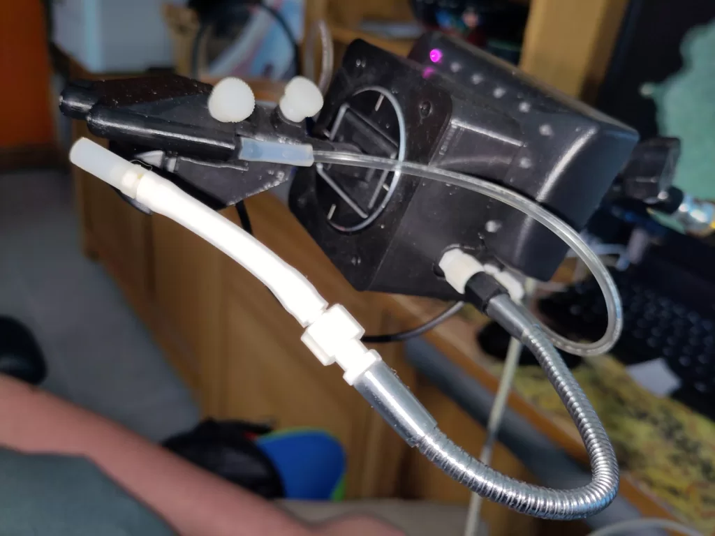 Close-up view of a Quadstick adaptive game controller, highlighting the mouthpiece with sip/puff sensors and attachments for hands-free gaming.