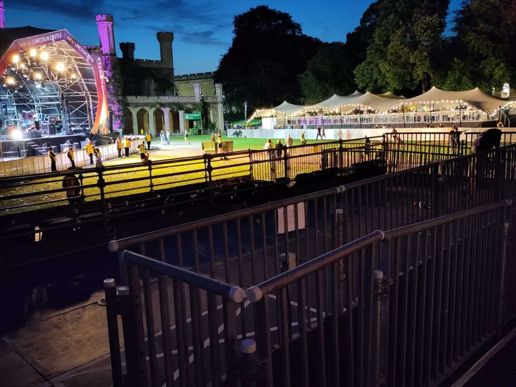 A view of the accessible viewing platform at Lincoln Castle Live, with the stage in the background and people enjoying the event.