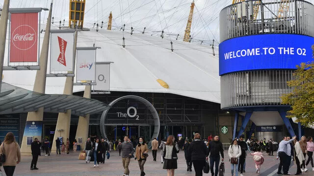 The O2 Arena entrance in London, showcasing the large white dome and signage, bustling with visitors.
