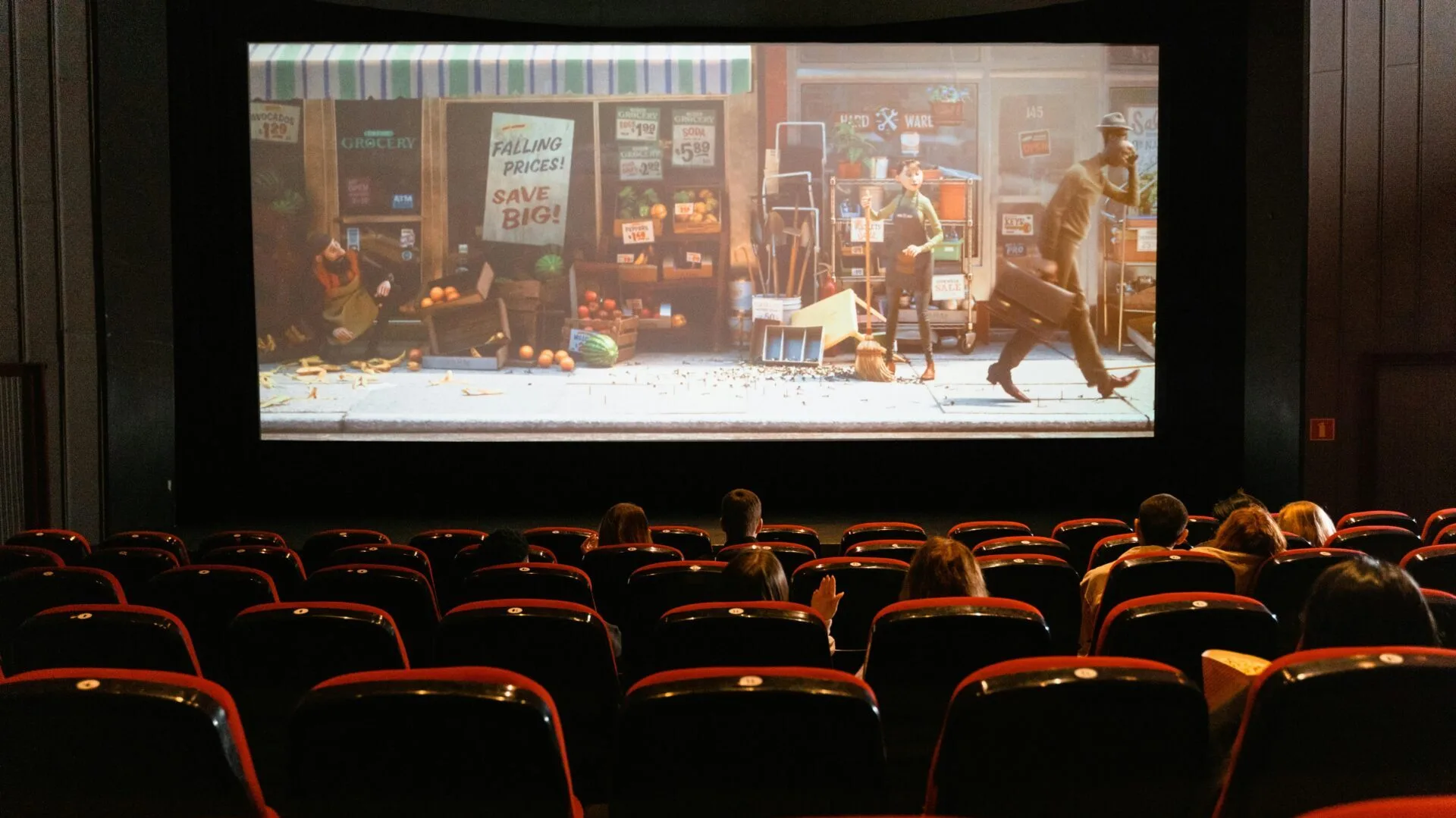 A cinema screen with  people sat in seats in the foreground